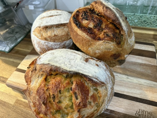 Assorted specialty sourdough loaves on a wooden board